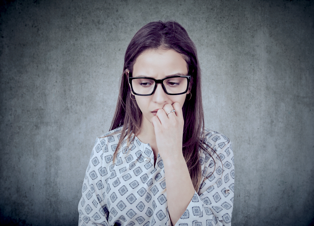 A woman wearing sunglasses looking anxious due to mental health problem.