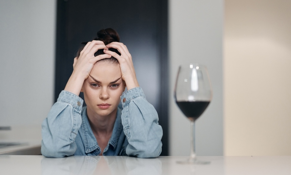 A closeup of a woman with a wine of glass in front of her