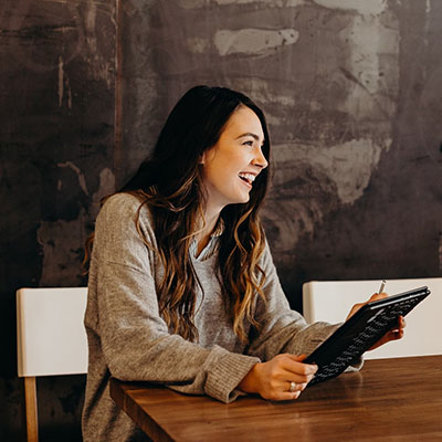 A happy woman holding a tab