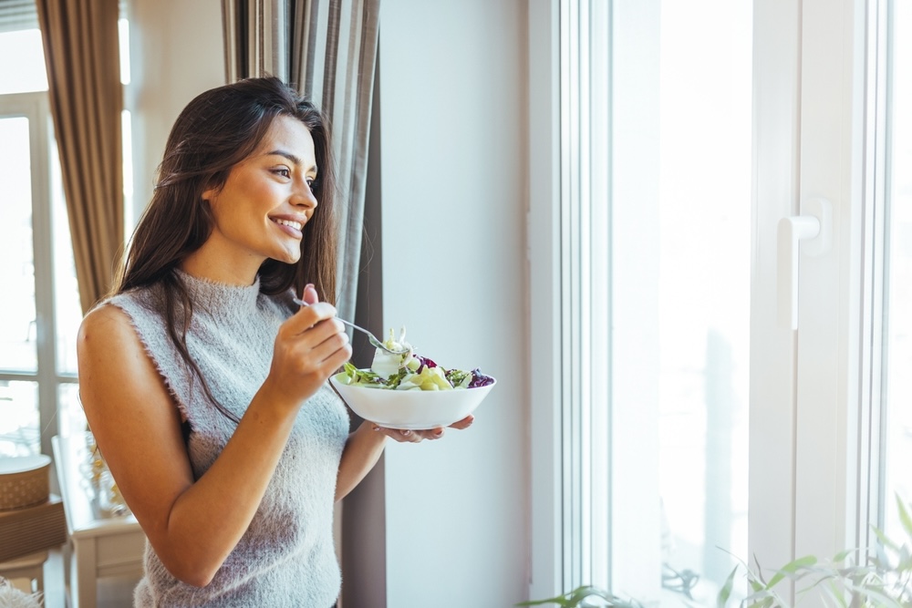 Woman eating healthy veggies and salad while in addiction treatment