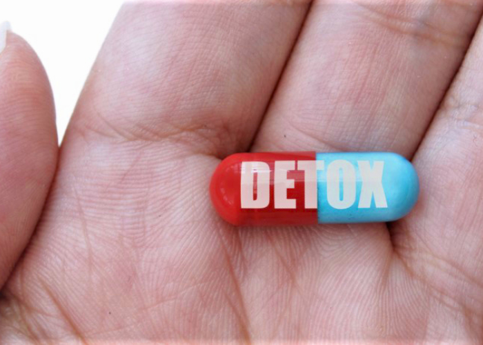 A hand with a written Detox Capsule