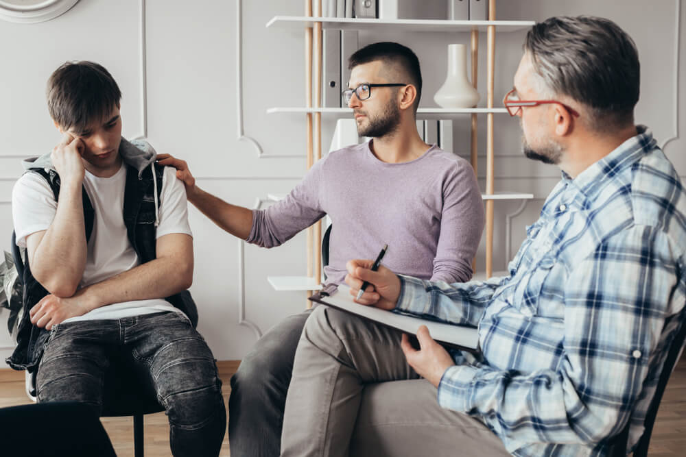 A guy with glasses consoling another guy with issues