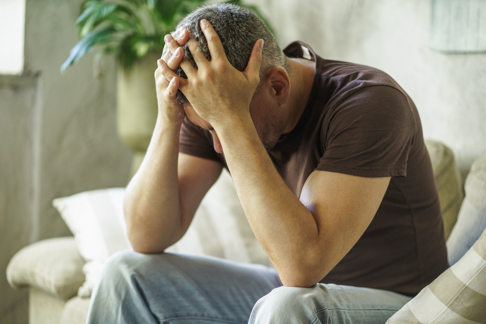 Depressed male sitting in a couch