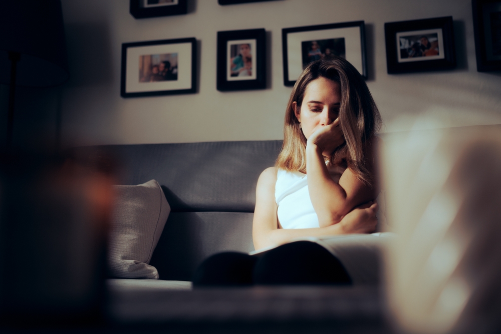 Depressed woman sitting in a couch