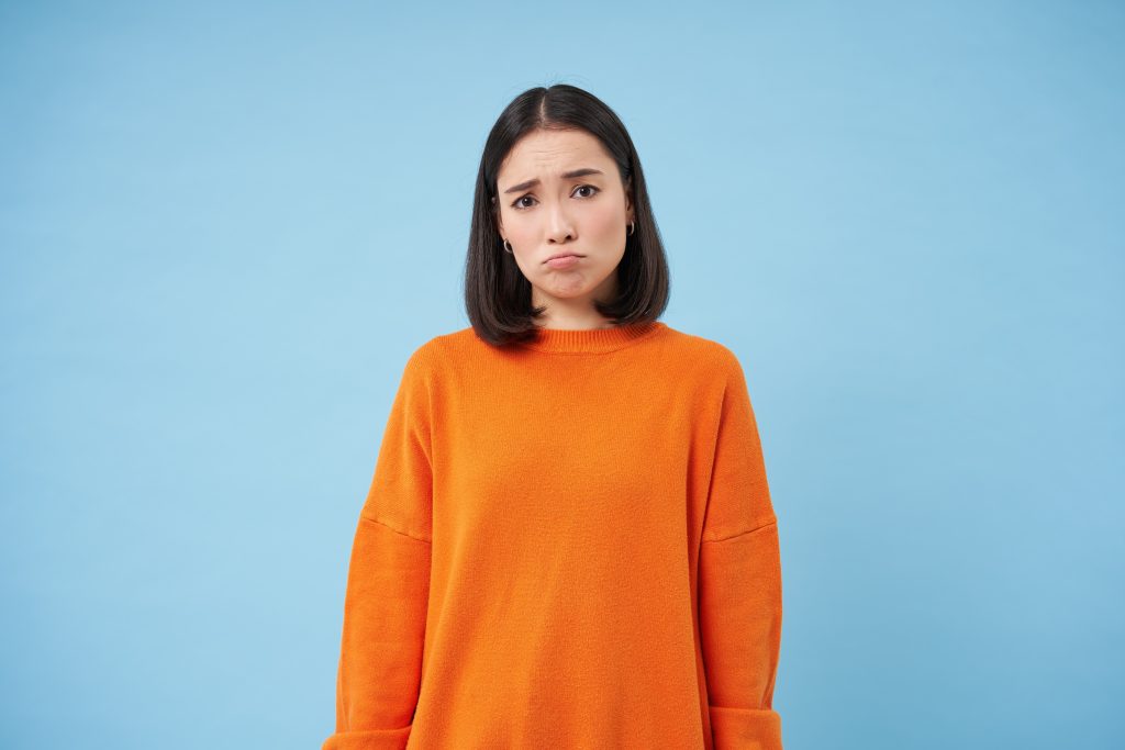 Sad and disappointed woman in an orange sweater