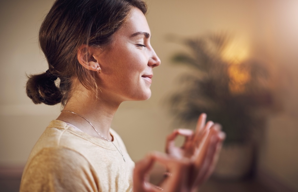 Woman with closed eyes doing mindful meditation