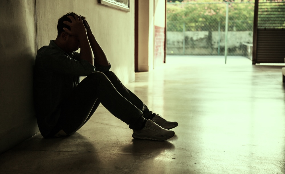 Desperate man in dark corner who is addicted to cocaine needing care and help.