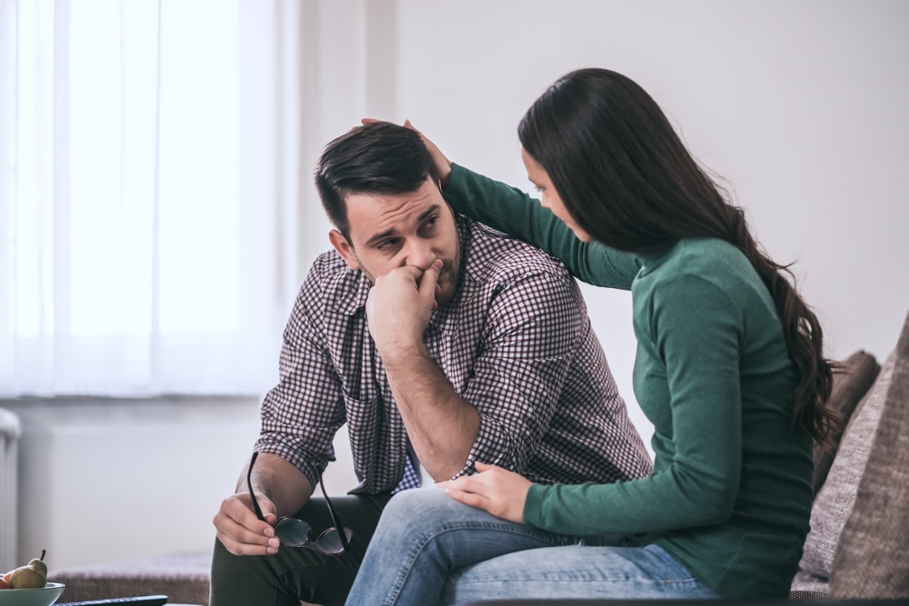 Woman comforting her husband who relapsed