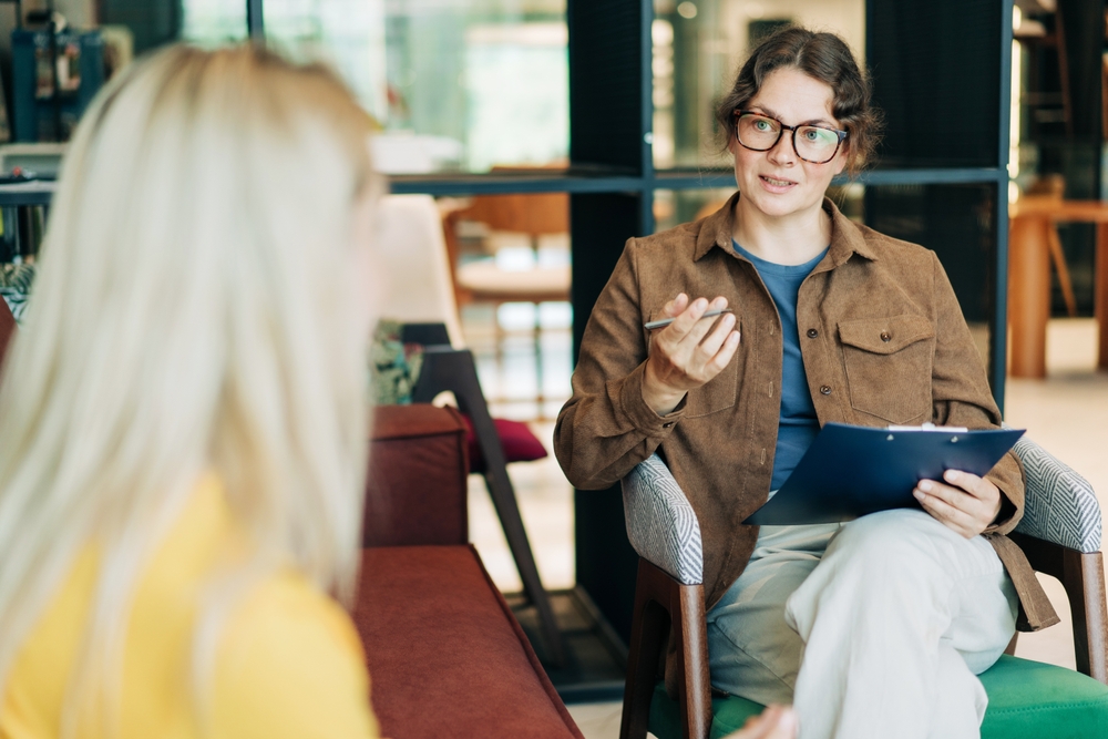 Psychologist wearing glasses explaining benefits of personalized addiction treatment