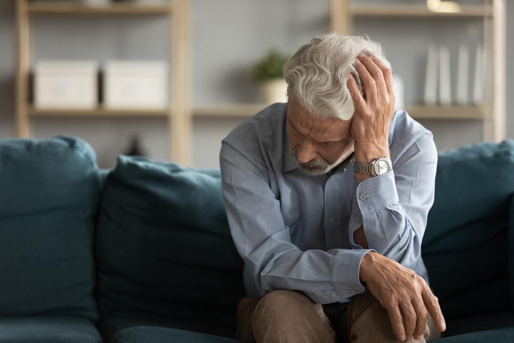 Man on a blue couch worried what will happen inside rehab