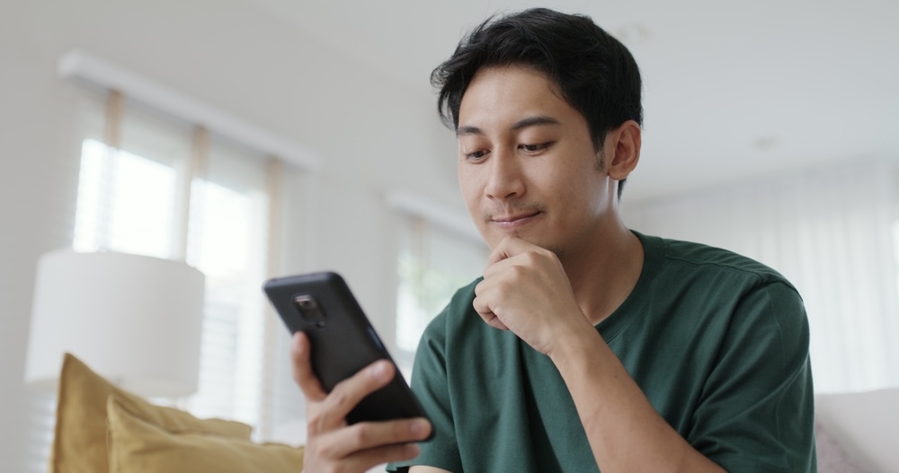 Male looks at his phone to find dates while in sobriety